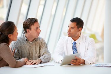 Couple discussing vasectomies with a doctor