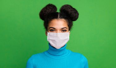 Woman wearing mask looking for coronavirus test kits