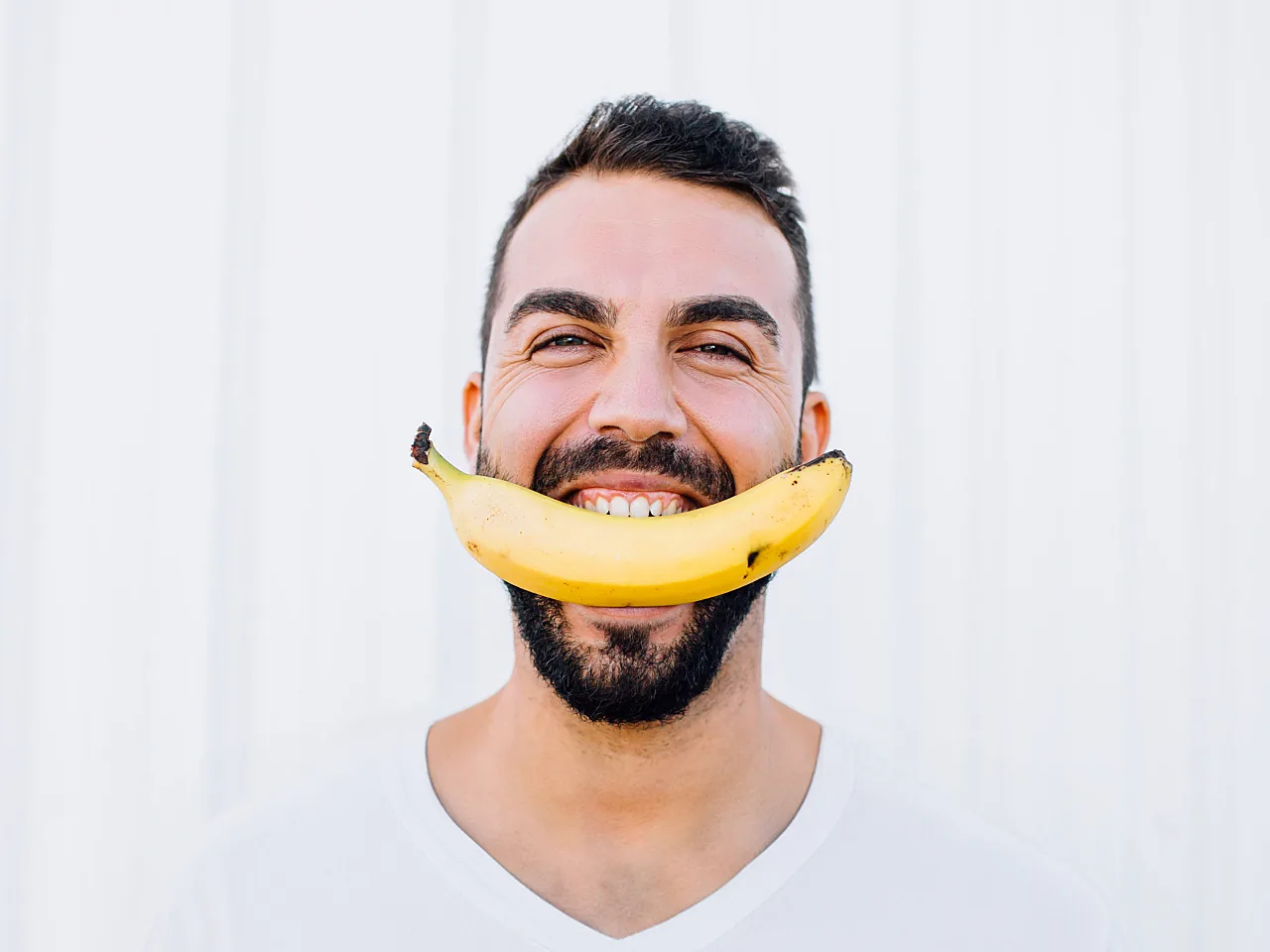 man holding banana in his mouth pleased with successful erectile dysfunction treatment