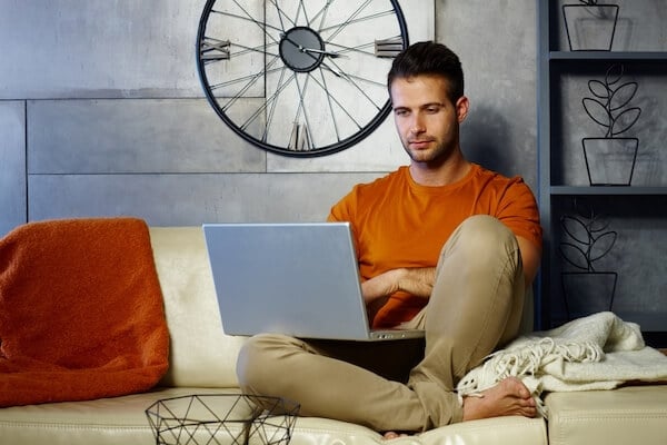 Man researching phimosis treatment on his laptop at home